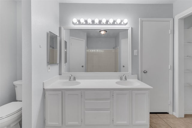 bathroom with tile patterned floors, vanity, toilet, and walk in shower