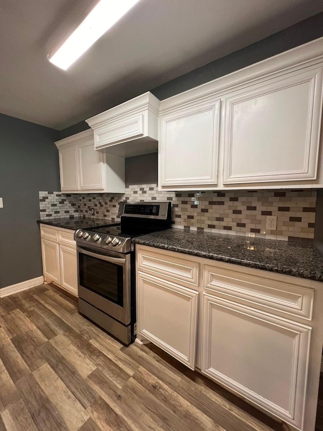 712 S Blackwell St, La Porte, TX 77571 - kitchen featuring stainless steel electric range, tasteful backsplash, dark wood-style flooring, white cabinets, and dark stone countertops