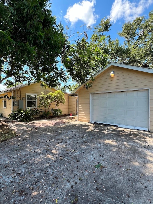 view of front facade featuring an outbuilding, aphalt driveway, and a garage