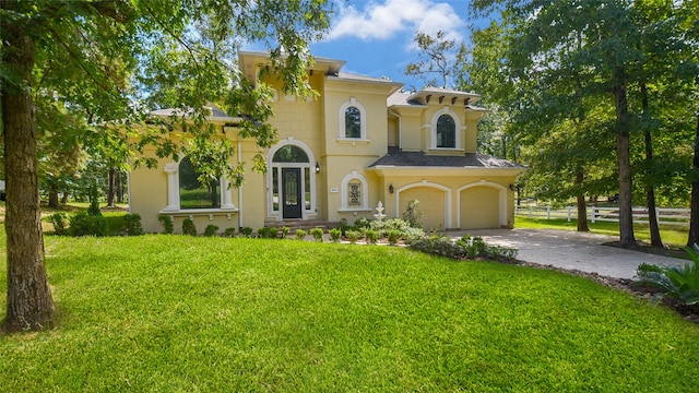 mediterranean / spanish-style home featuring a garage and a front yard