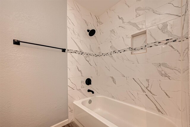 bathroom featuring tiled shower / bath