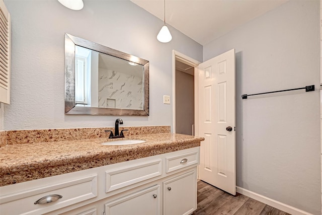 bathroom featuring vanity, wood finished floors, and baseboards