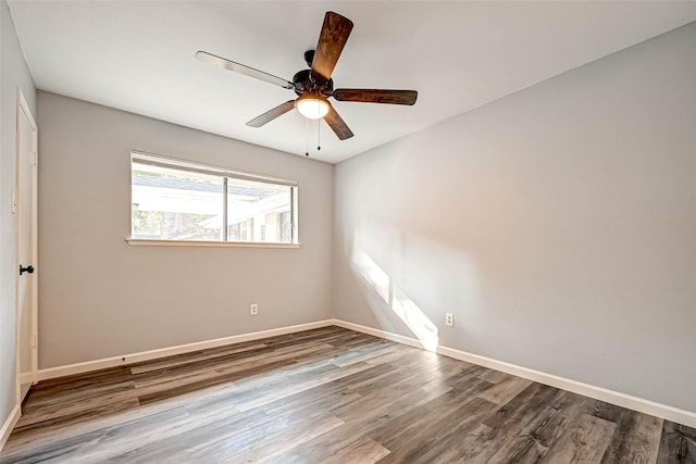 spare room featuring a ceiling fan, wood finished floors, and baseboards