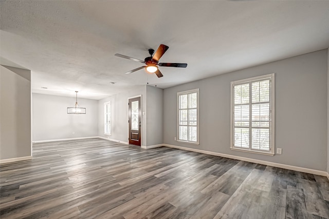 empty room featuring a textured ceiling, dark hardwood / wood-style floors, and ceiling fan