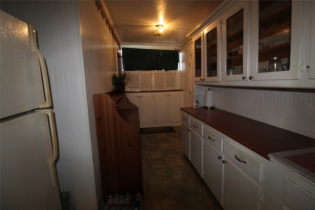 kitchen with dark tile patterned flooring, white cabinetry, and white refrigerator