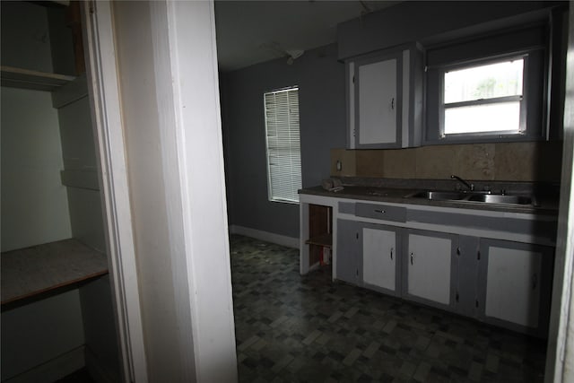 kitchen with sink, white cabinetry, and dark tile patterned flooring