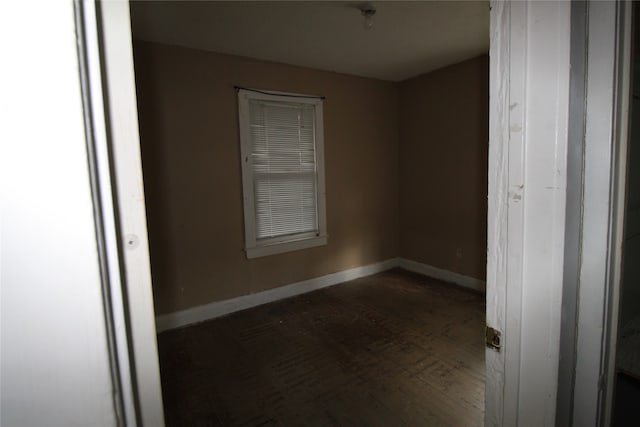 empty room with dark hardwood / wood-style flooring