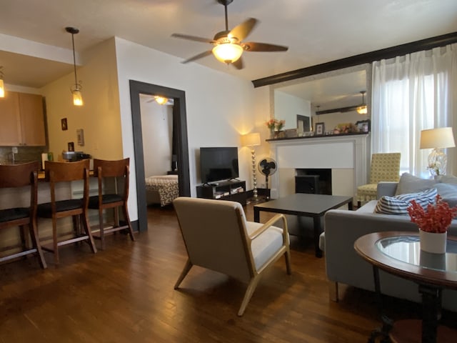 living room with ceiling fan and dark wood-type flooring