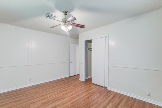 unfurnished bedroom with ceiling fan, light hardwood / wood-style flooring, and a closet