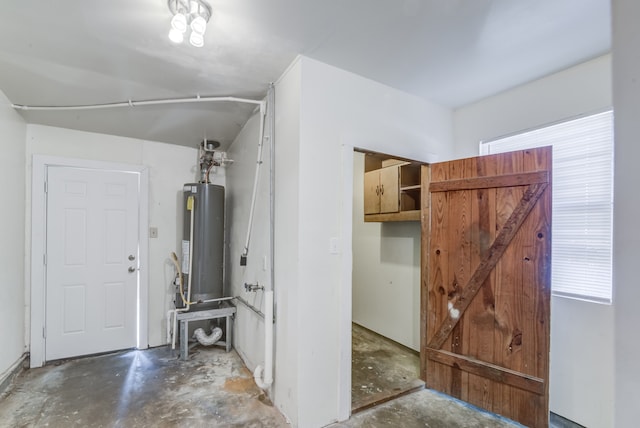 interior space with gas water heater and concrete floors