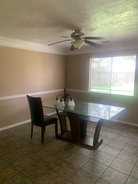 unfurnished dining area featuring ceiling fan with notable chandelier, ornamental molding, a textured ceiling, and tile patterned floors