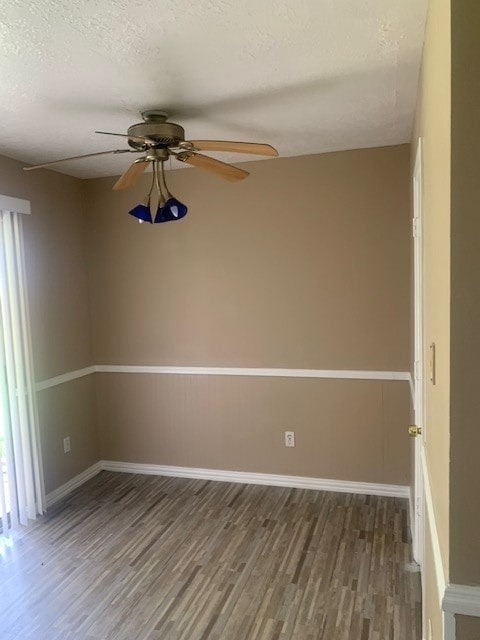 empty room featuring ceiling fan, a textured ceiling, and wood-type flooring