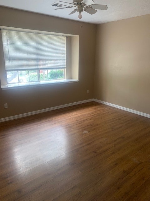 spare room with ceiling fan and hardwood / wood-style flooring