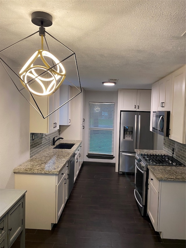 kitchen with white cabinets, decorative backsplash, appliances with stainless steel finishes, and dark hardwood / wood-style floors