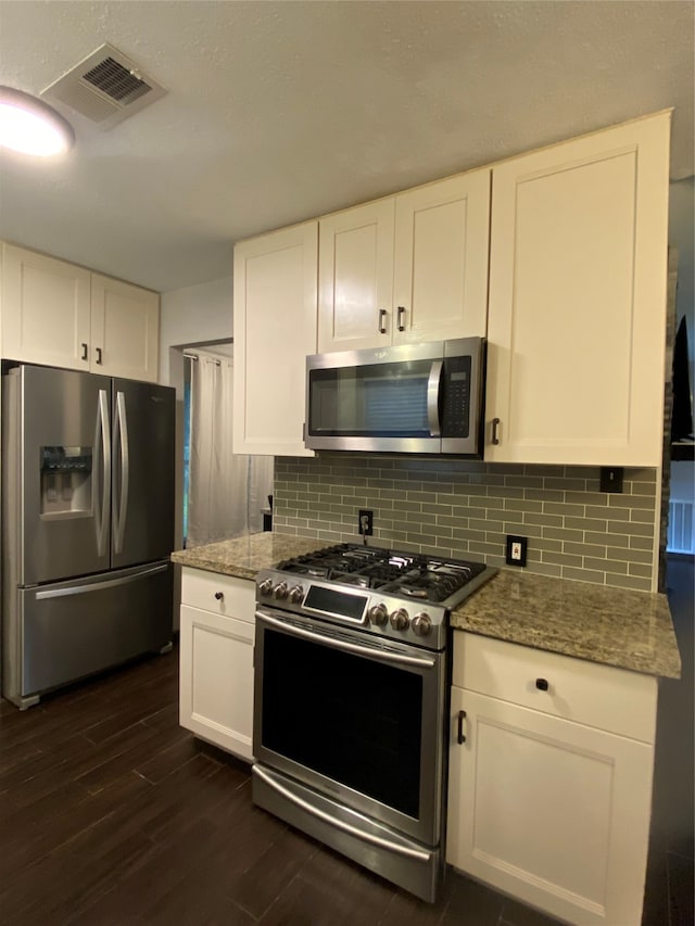 kitchen featuring tasteful backsplash, light stone counters, stainless steel appliances, white cabinetry, and dark hardwood / wood-style floors