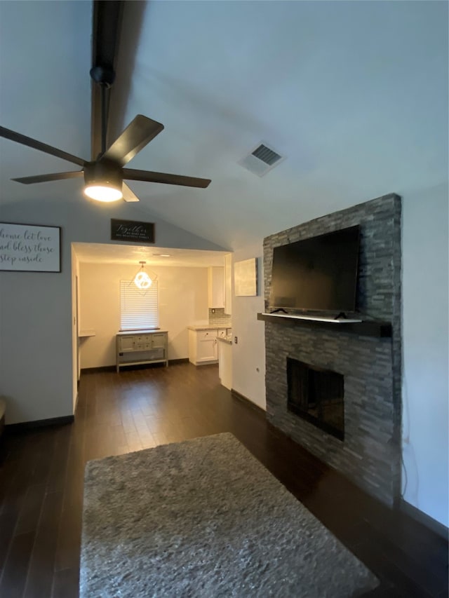 unfurnished living room featuring a stone fireplace, ceiling fan, lofted ceiling, and dark hardwood / wood-style floors