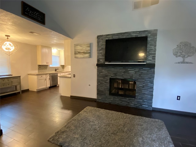 living room featuring a fireplace, dark wood-type flooring, and vaulted ceiling