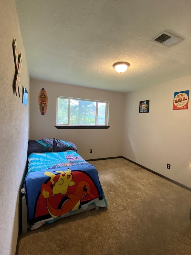 bedroom with a textured ceiling and carpet flooring