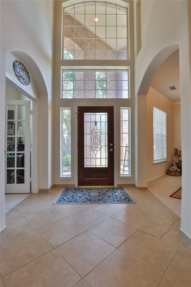 entryway featuring light tile patterned floors and a high ceiling