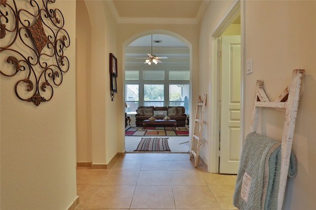 corridor with light tile patterned flooring and ornamental molding