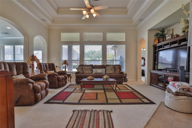 living room featuring ceiling fan, a raised ceiling, and ornamental molding