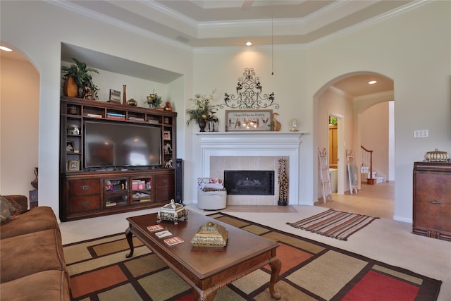 carpeted living room featuring a fireplace, crown molding, and a tray ceiling