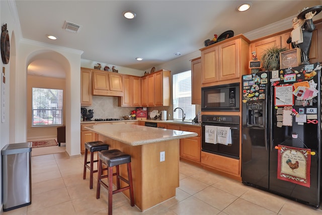 kitchen with light tile patterned flooring, crown molding, decorative backsplash, and black appliances