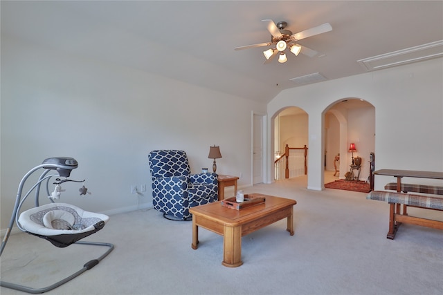 carpeted living room with ceiling fan and vaulted ceiling