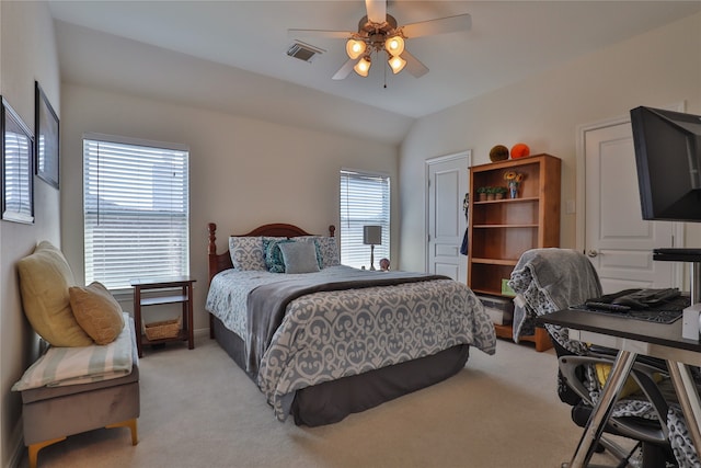 bedroom featuring ceiling fan, multiple windows, light colored carpet, and lofted ceiling