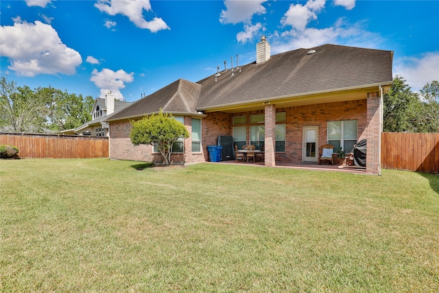 rear view of house with a patio area and a yard