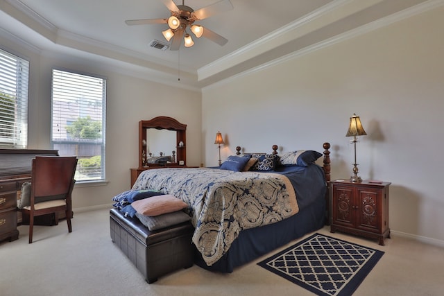 bedroom with ceiling fan, a raised ceiling, crown molding, and light colored carpet