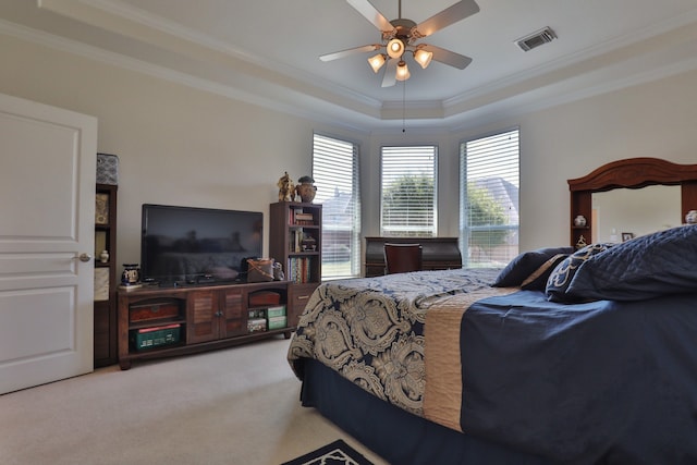 bedroom with ceiling fan, carpet floors, multiple windows, and a tray ceiling