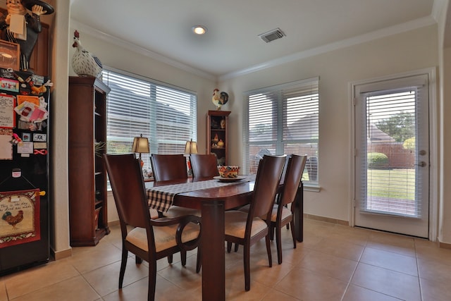 tiled dining room featuring crown molding