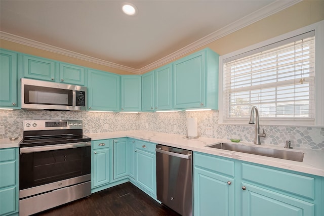 610 Surf Dr, Surfside Beach, TX 77541 - kitchen with crown molding, a sink, appliances with stainless steel finishes, light countertops, and dark wood finished floors