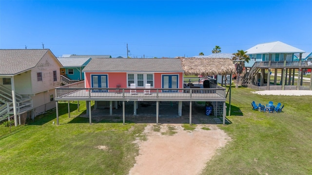 610 Surf Dr, Surfside Beach, TX 77541 - rear view of property with a wooden deck, driveway, and a lawn