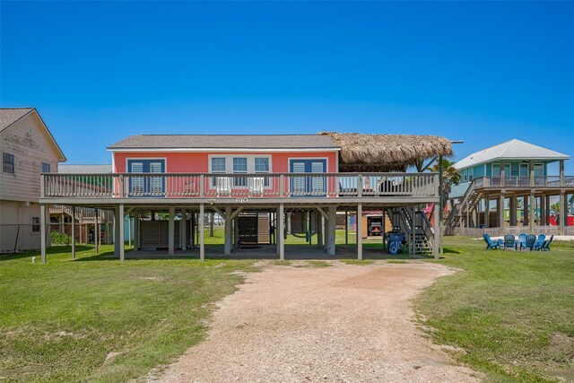 610 Surf Dr, Surfside Beach, TX 77541 - rear view of property with a carport, dirt driveway, a wooden deck, a lawn, and stairway