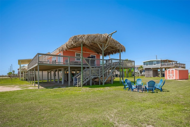 610 Surf Dr, Surfside Beach, TX 77541 - exterior space with a wooden deck, an outdoor fire pit, an outdoor structure, stairs, and a storage unit