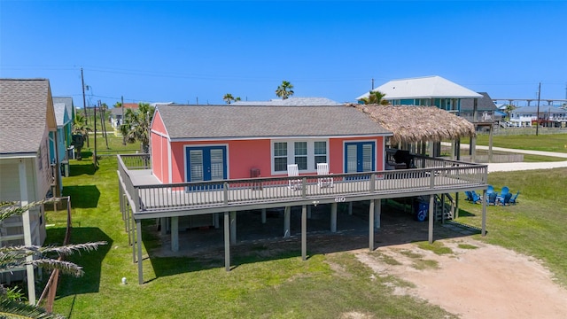 610 Surf Dr, Surfside Beach, TX 77541 - rear view of property with a residential view, a lawn, a wooden deck, and a shingled roof