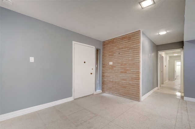 tiled spare room with wood walls