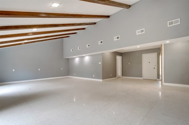 tiled spare room featuring beam ceiling and high vaulted ceiling