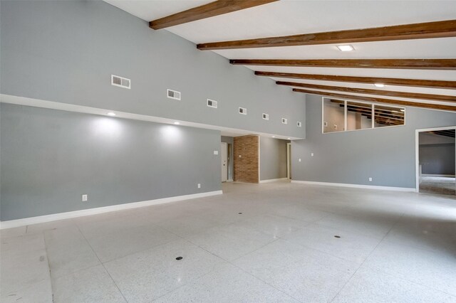 unfurnished room featuring beam ceiling and high vaulted ceiling