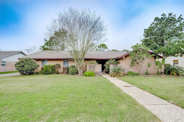 ranch-style home featuring brick siding and a front yard