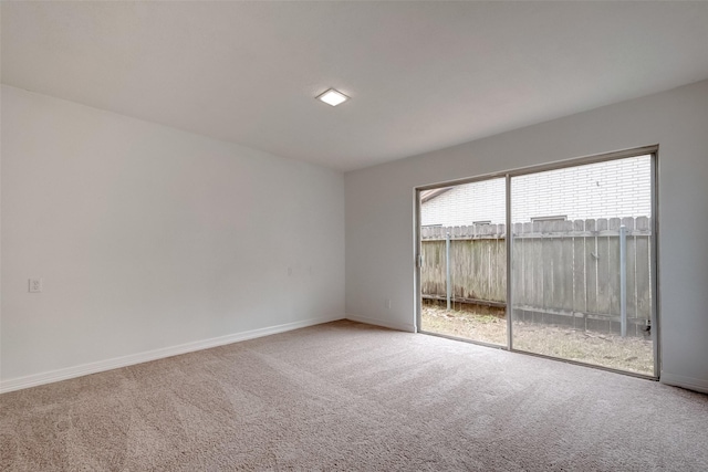 empty room featuring carpet and baseboards