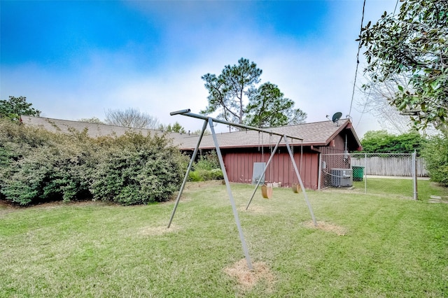 view of yard featuring central AC and fence