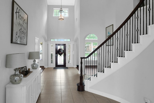 tiled entryway featuring a towering ceiling