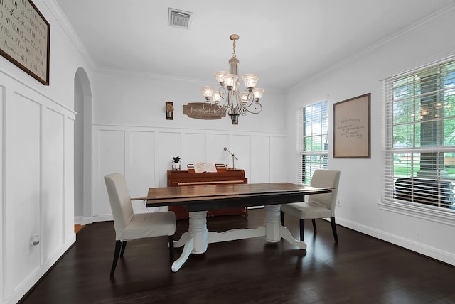 dining area with an inviting chandelier, dark wood-type flooring, and ornamental molding