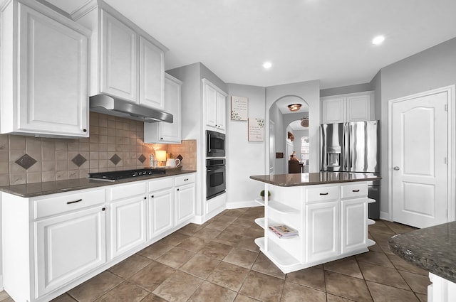 kitchen with backsplash, tile patterned floors, white cabinetry, appliances with stainless steel finishes, and a center island