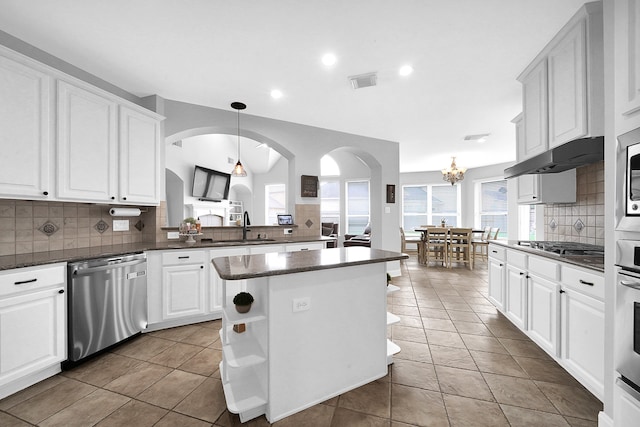 kitchen featuring a center island, backsplash, sink, and appliances with stainless steel finishes