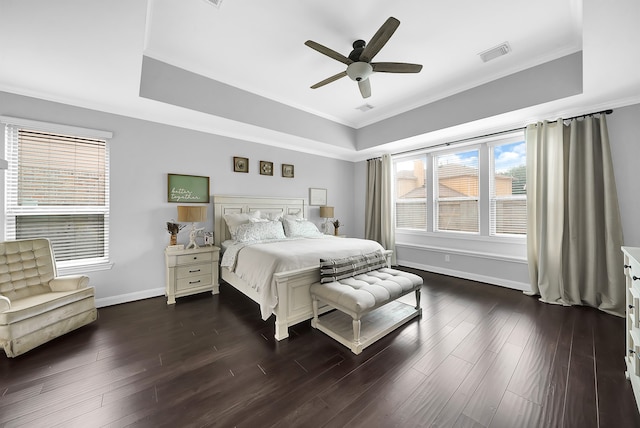 bedroom featuring ceiling fan, a raised ceiling, dark wood-type flooring, and ornamental molding