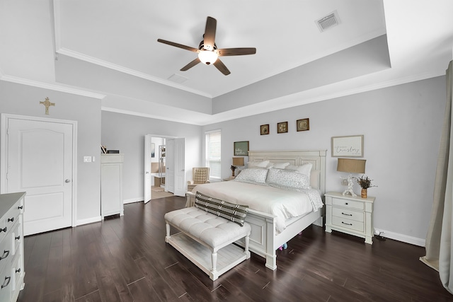 bedroom featuring ensuite bath, dark hardwood / wood-style floors, ceiling fan, a raised ceiling, and crown molding